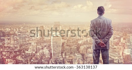 Businessman looking across the city of London financial district concept for entrepreneur, leadership and success