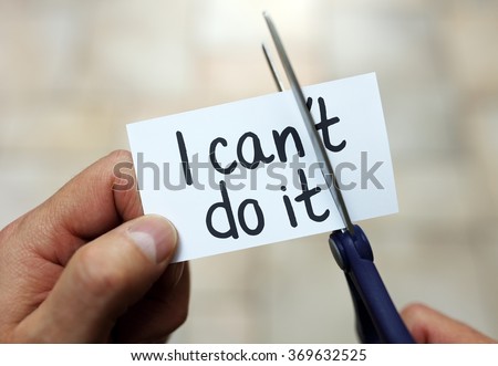 Man using scissors to remove the word can\'t to read I can do it concept for self belief, positive attitude and  motivation