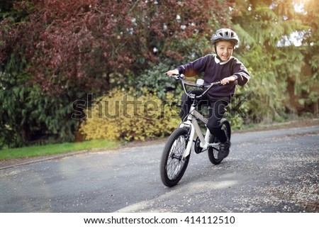 Boy learning to ride his bike home from school
