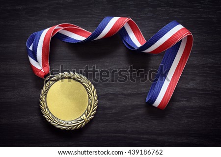 Gold medal on black wood background with blank face for text, concept for winning or success