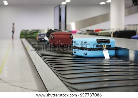 Suitcase or luggage on conveyor belt in the airport waiting