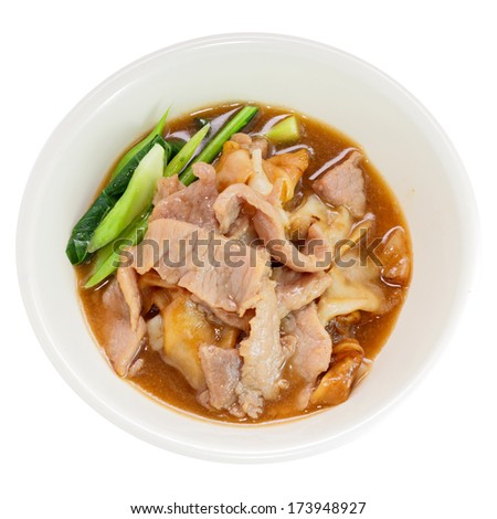 Fried noodle with pork and kale soaked in gravy, Thailand food on a white round bowl isolated over white background. Top view.