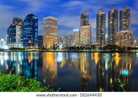 Night cityscape, office buildings and apartments in Thailand at dusk. View from public park.