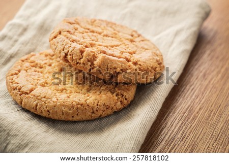 Pastry biscuits on linen napkin on wooden table. Pastry biscuits shot on coffee colored cloth, closeup with selective focus.