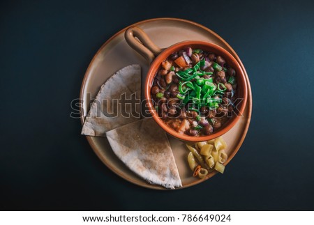 A high angle view/color studio image of Egyptian, Arabian, Middle Eastern Traditional food (Fava Beans with Vegetables/Green Paprika) A.K.A (Foul) - Also served in Lebanon and most of Arabian countrie