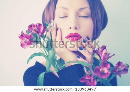 Art portrait of beautiful young lady with delicate flowers
