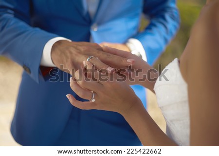 The bride wears a wedding ring on the groom. Closeup photo