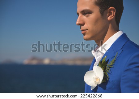 Fashion portrait of a handsome groom in blue suit