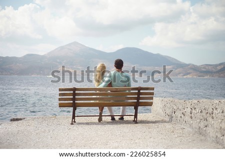 Romantic couple by the sea looking into the distance