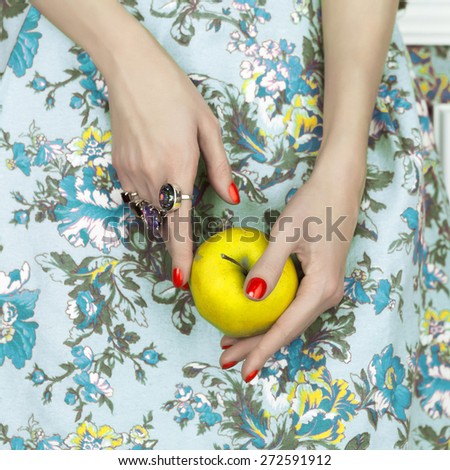 Woman\'s hands holding a green apple. Fashion art photo. Beauty, Jewelry and Manicure