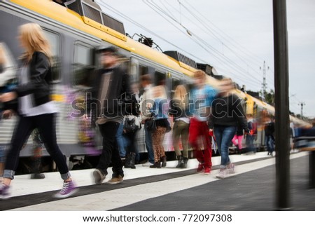 Morning rush hour at the train station with many teenage students hurrying to catch the train to go to school. Blurred for anonymity.
