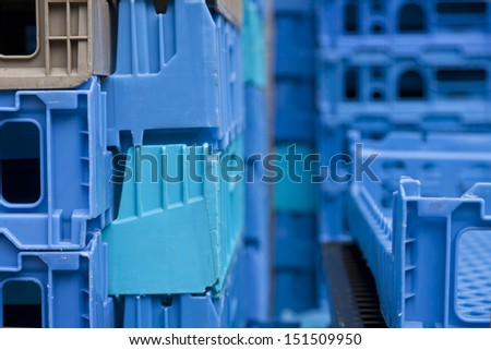 A stack of blue service trays piled up outside background texture and detail.