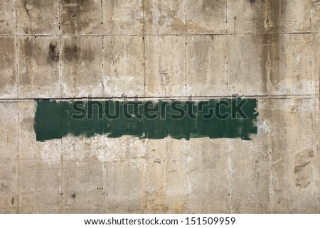 Green pain on a concrete barrier wall for background or texture.