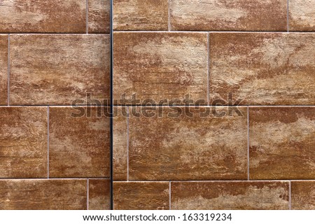 A flat wall made with textured stone tiles with lots of detail and texture for background. High Resolution.
