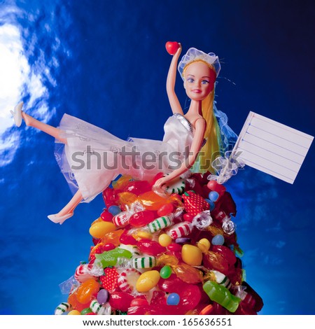 A generic doll and a pile of candy interact humorously.