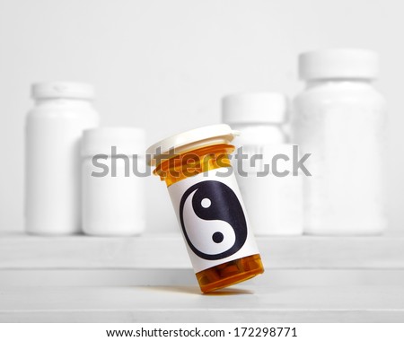 A pill bottle with a yin and yang symbol on the label.