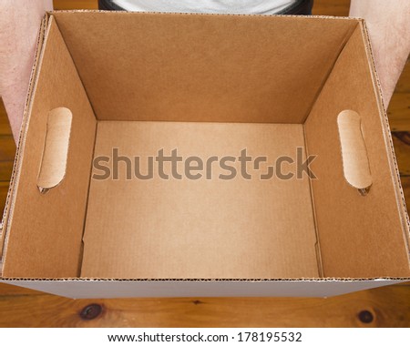 A caucasian male holding an empty cardboard box.