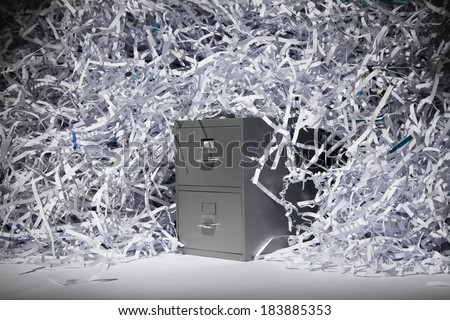 A file cabinet surrounded by a mountain of shredded paper.