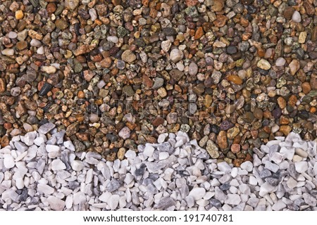 Gravel background with small white marble pebbles in a wave shape at the bottom.