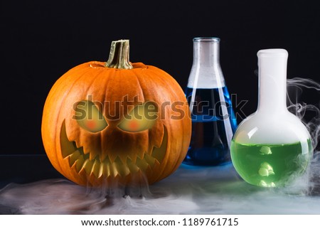Scary Halloween pumpkin with smoke and laboratory equipment on table