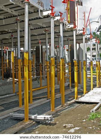 support posts holding cement floor slabs on construction site,\