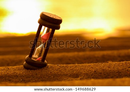 Closeup Of Hourglass On The Sand.Timer Beach Sunrise