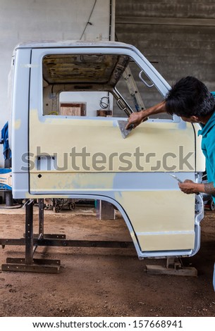 Mechanic preparing the body of a car for a paint repair job