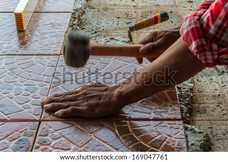 Construction mason worker floor tile installation. Home improvement.