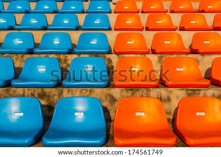 The empty blue and orange stadium seat for watch some sport or football.
