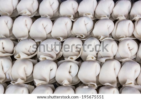 Raw wonton in row, chinese food texture background.