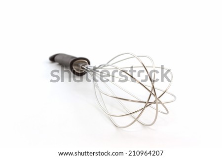 Metal whisk for whipping eggs on white background, House ware.