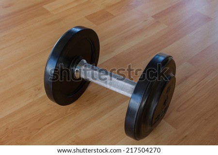 Black Weights dumbbells on wood background.