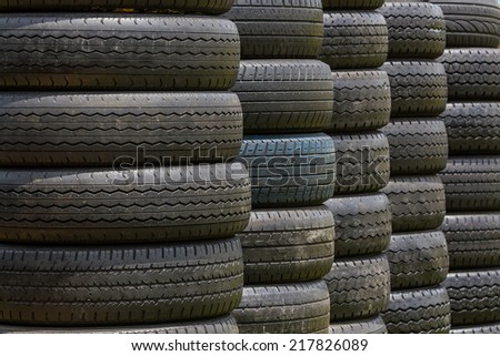 Stack of old wheel black tyres texture background.
