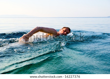 swimming man in clean ocean water