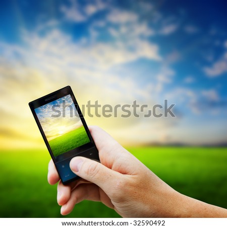 cell phone in hand and country sunset