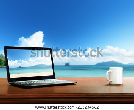 notebook on table and tropical beach