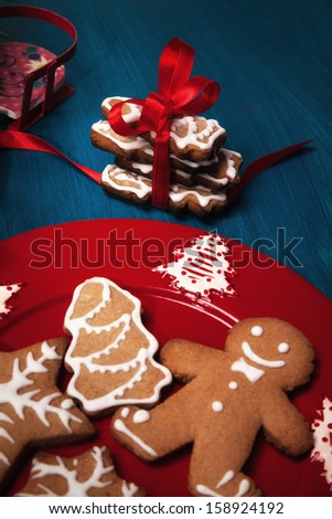 Gingerbread Christmas cookies with red ribbon on red plate