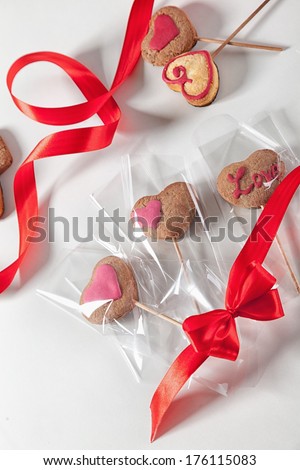 Homemade heart shape cookies on a stick packed as a gift.