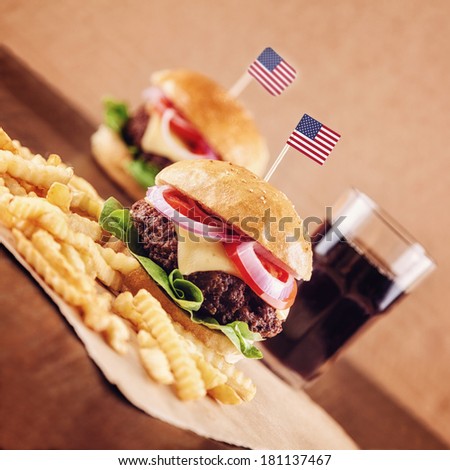 American Ground beef Cheese Burger with Lettuce,Tomato and Red Onion with French Fries and glass of Cola