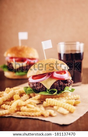 Ground beef Cheese Burger with Lettuce,Tomato and Red Onion with French Fries and glass of Cola