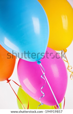 Bunch of colorful helium balloons isolated on a white background.