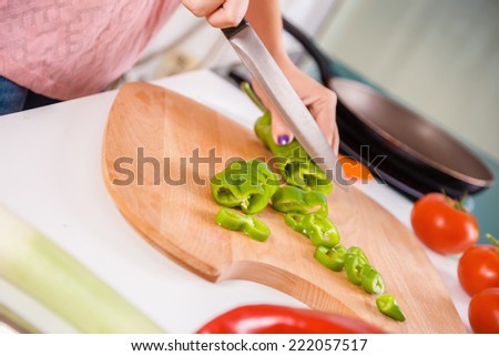 Close Up Of Housewives Hands Slicing Vegetables On Chopping Board