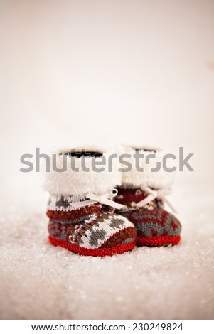 Christmas Baby Slippers On Snowy Background