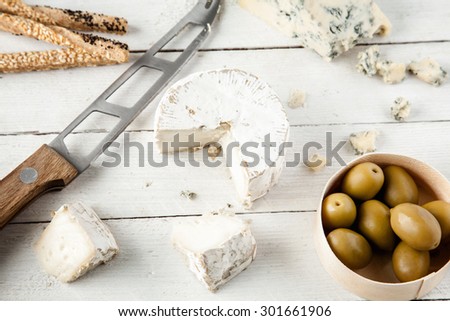 Preparing Tasty Snack With Blue Cheese, Goat Cheese And Olives