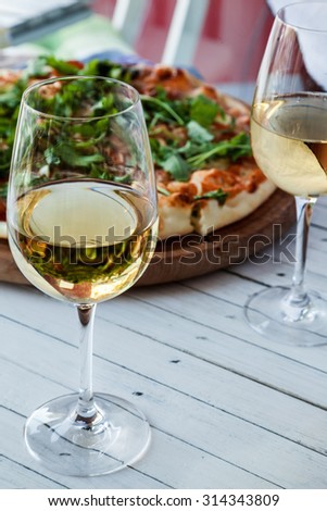 Two Glass Of White Wine And Pizza On Wooden Board