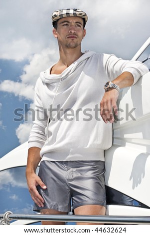 young attractive man looking away on a yacht, with a cloudy background .