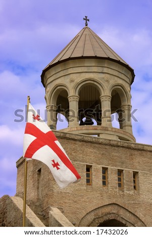 Georgian flag over orthodox monastery with blue sky