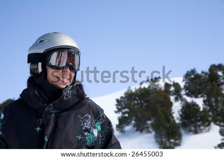 Pretty girl in snowboard clothes in helmet over blue sky
