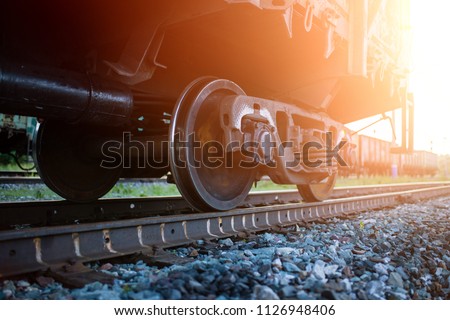 The railway engine of a freight locomotive that crosses the desert during sunset.\
Large transport of goods in tanks by rail. railway rails