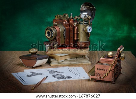 Photo camera and drawing on a wooden table. Style Steampunk.
